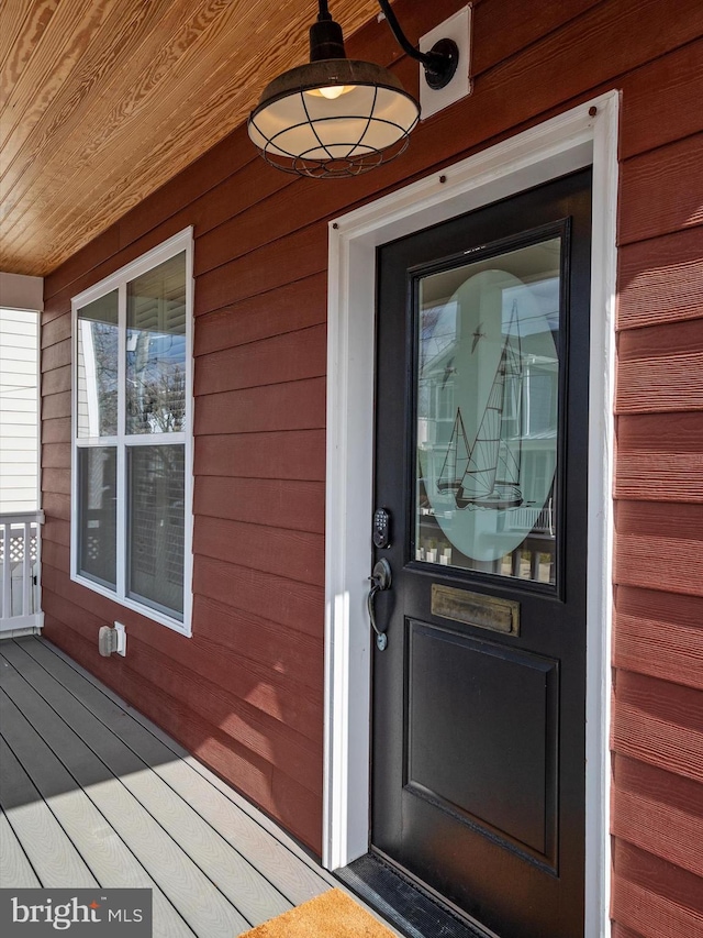 entrance to property with covered porch and ceiling fan