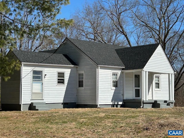 view of front of property with entry steps, crawl space, roof with shingles, and a front lawn