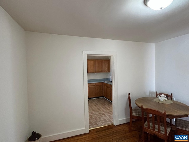 dining room with dark wood finished floors and baseboards