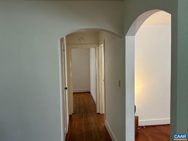 hallway with dark wood-style floors and baseboards