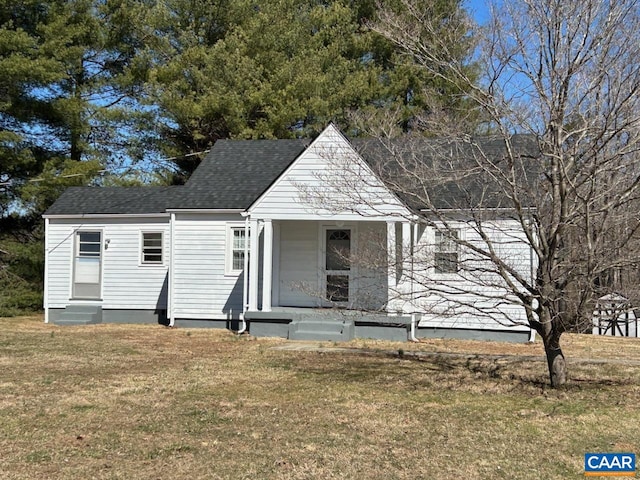 view of front facade featuring entry steps, a front lawn, and roof with shingles