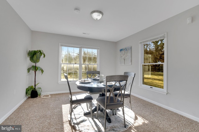 carpeted dining space with visible vents and baseboards