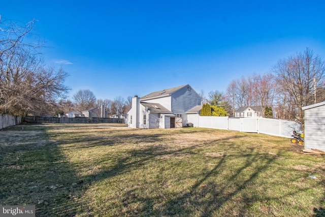 view of yard featuring a fenced backyard and an outdoor structure