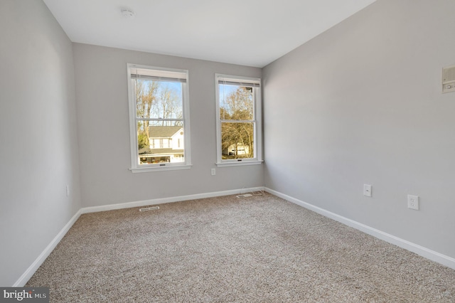 carpeted empty room with visible vents and baseboards