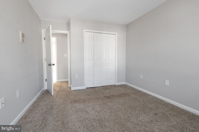 unfurnished bedroom featuring carpet, baseboards, and a closet