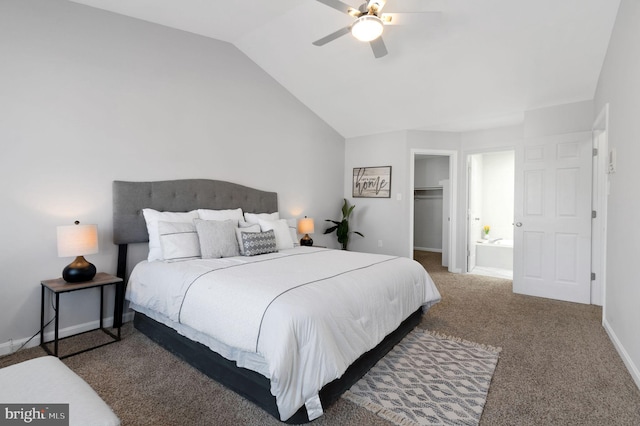 carpeted bedroom featuring a ceiling fan, baseboards, vaulted ceiling, a closet, and a walk in closet