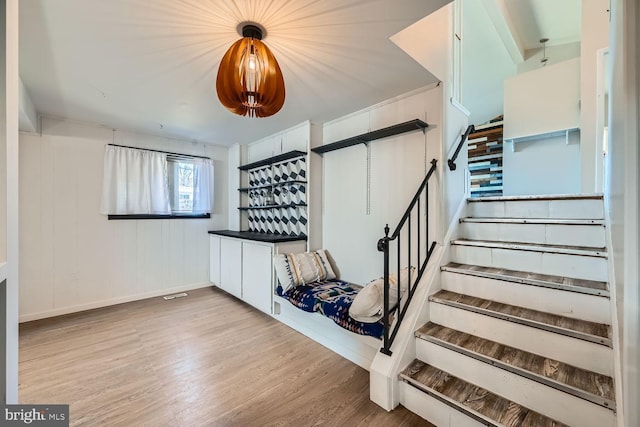 staircase with a bar and wood finished floors