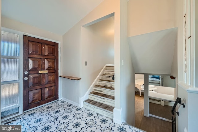 entrance foyer with lofted ceiling, baseboards, and stairway