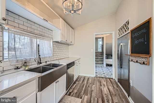 kitchen featuring vaulted ceiling, appliances with stainless steel finishes, dark wood-style floors, and white cabinetry