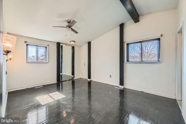 empty room featuring wood-type flooring, a healthy amount of sunlight, lofted ceiling with beams, and baseboards