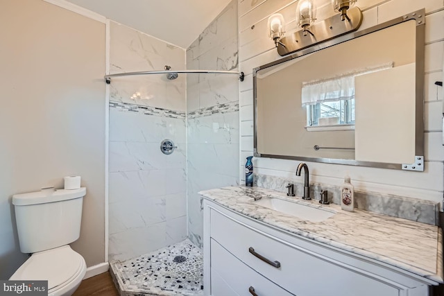 bathroom with a stall shower, vanity, and toilet