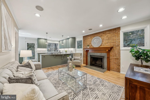 living room featuring crown molding, recessed lighting, and light wood-style floors