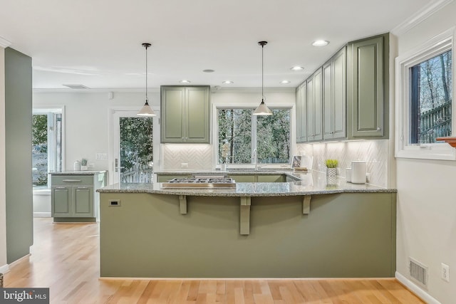 kitchen featuring light stone counters, plenty of natural light, and light wood-style flooring