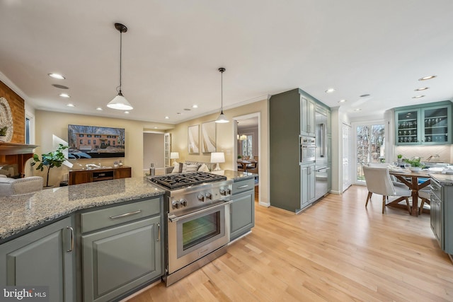 kitchen with decorative light fixtures, light wood-style floors, gray cabinets, and stainless steel appliances