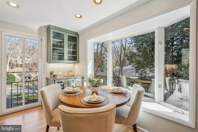 dining area with recessed lighting, light wood-style flooring, and crown molding