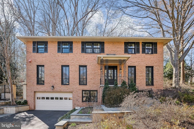 view of front of house with aphalt driveway, brick siding, and a garage