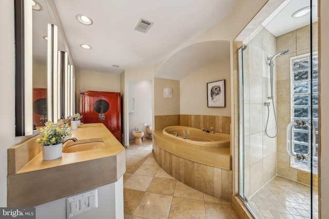 bathroom featuring visible vents, a shower stall, a garden tub, and a sink