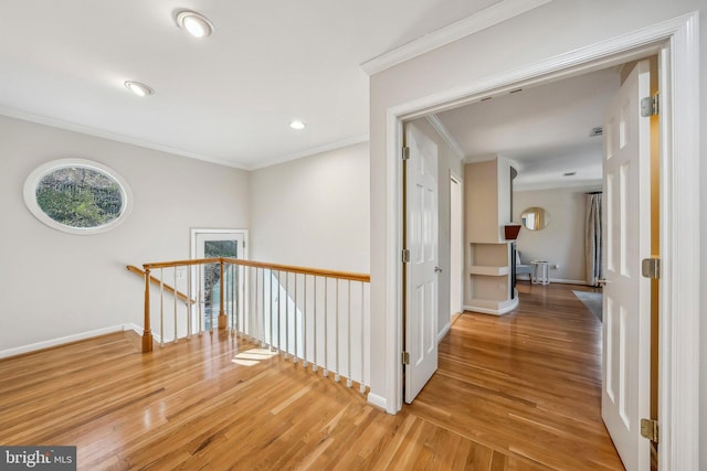 hall featuring an upstairs landing, baseboards, wood finished floors, and crown molding