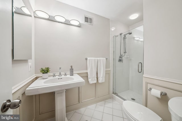 bathroom with tile patterned floors, visible vents, toilet, and a shower stall