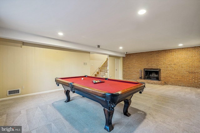 recreation room featuring visible vents, a brick fireplace, brick wall, and carpet floors