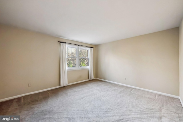 carpeted spare room with baseboards