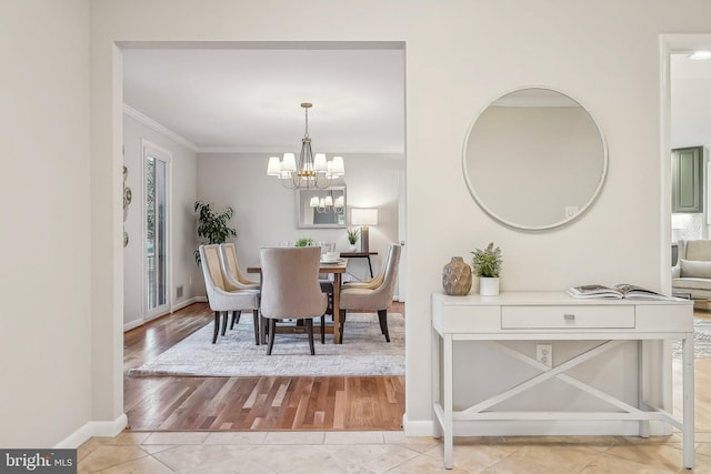 dining room with baseboards, a notable chandelier, light tile patterned flooring, and crown molding