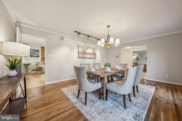 dining area featuring ornamental molding, baseboards, and wood finished floors