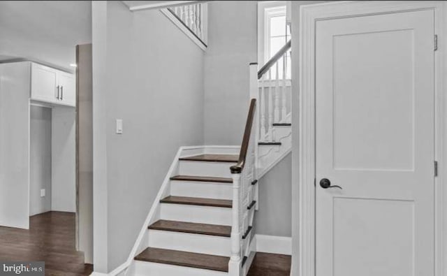 stairway featuring wood finished floors and baseboards