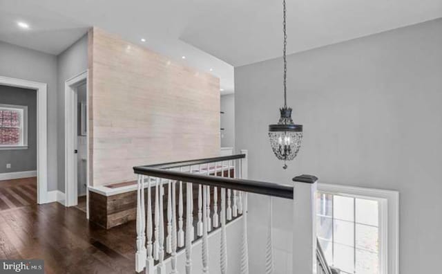 corridor with baseboards, dark wood-style floors, an upstairs landing, a chandelier, and recessed lighting