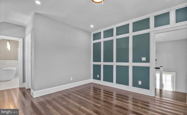 spare room with baseboards, wood finished floors, lofted ceiling, and recessed lighting