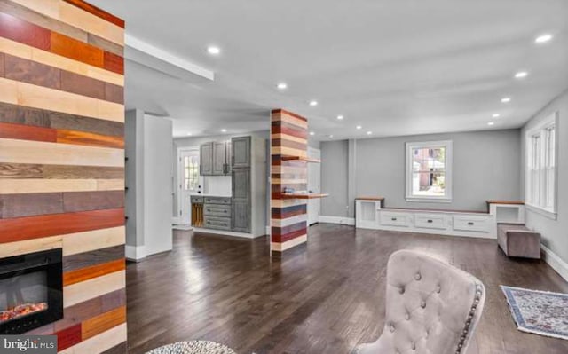 living room with baseboards, wood finished floors, a glass covered fireplace, and recessed lighting