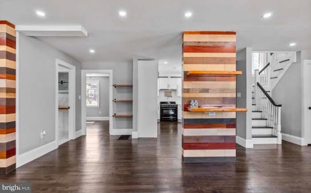 unfurnished living room with baseboards, stairway, wood finished floors, and recessed lighting