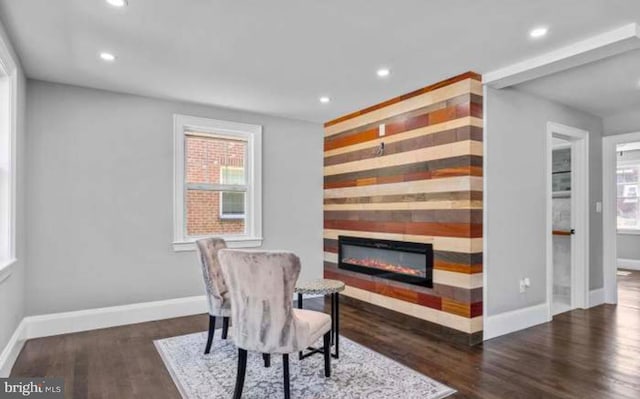 living area featuring recessed lighting, baseboards, wood finished floors, and a glass covered fireplace