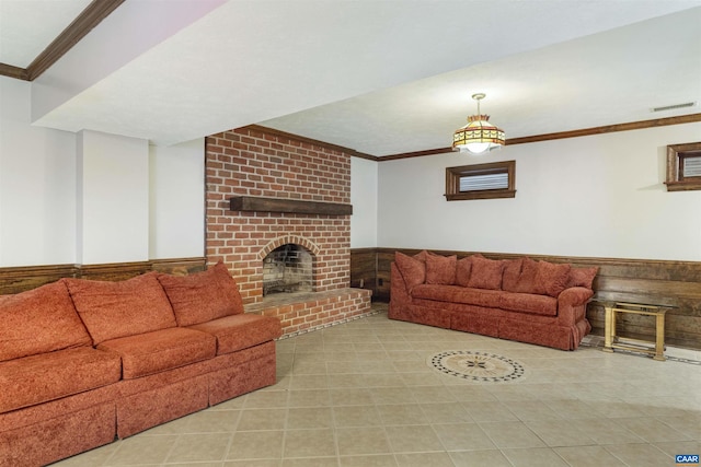 living room with wainscoting, a fireplace, visible vents, and crown molding