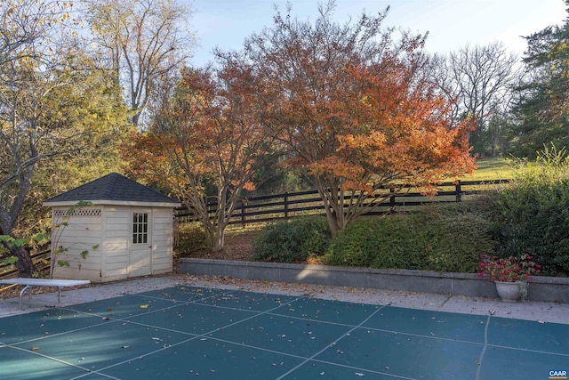 view of pool featuring a storage shed, an outdoor structure, fence, and a fenced in pool