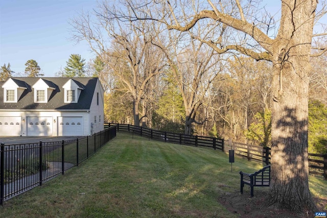 view of yard with a detached garage and fence