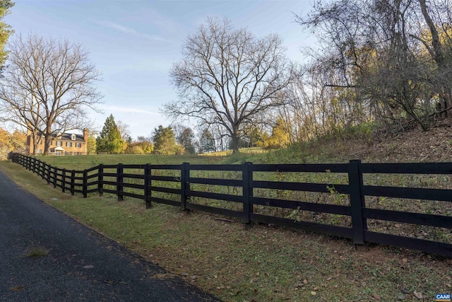 view of gate featuring a yard, a rural view, and fence