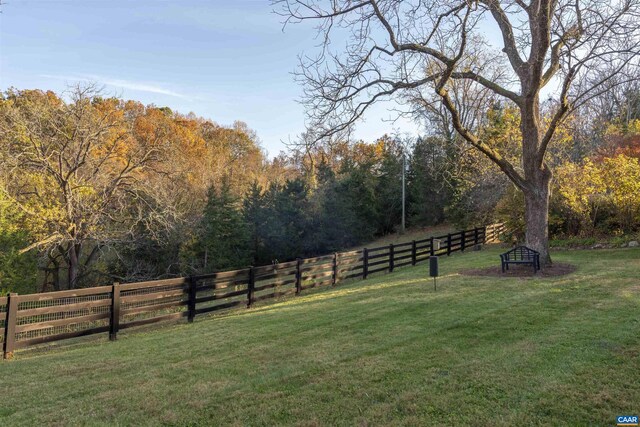 view of yard with fence and a view of trees