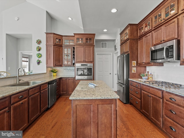 kitchen with light wood finished floors, stainless steel appliances, visible vents, a sink, and light stone countertops