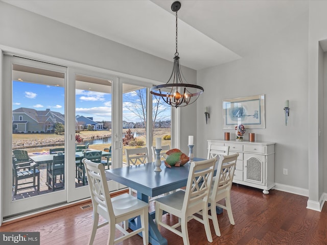 dining area featuring an inviting chandelier, baseboards, and dark wood-style flooring