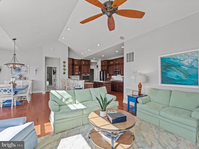 living area with baseboards, visible vents, wood finished floors, ceiling fan with notable chandelier, and recessed lighting