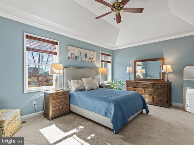 carpeted bedroom with visible vents, a ceiling fan, baseboards, a tray ceiling, and crown molding