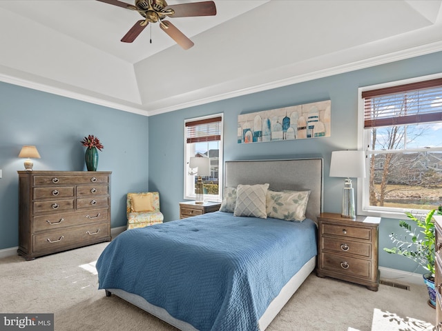 carpeted bedroom featuring multiple windows, baseboards, vaulted ceiling, and a tray ceiling