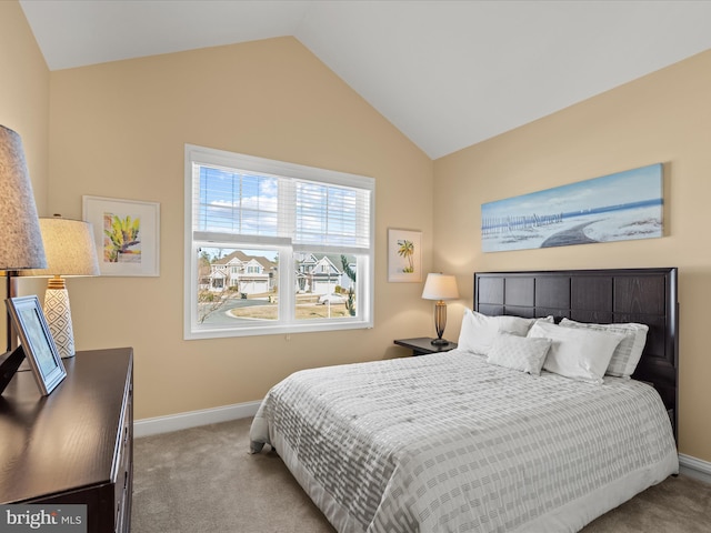 bedroom with carpet floors, lofted ceiling, and baseboards