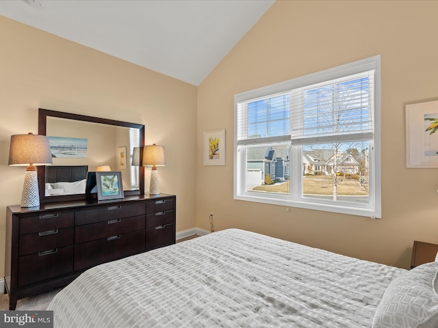 carpeted bedroom with baseboards and vaulted ceiling