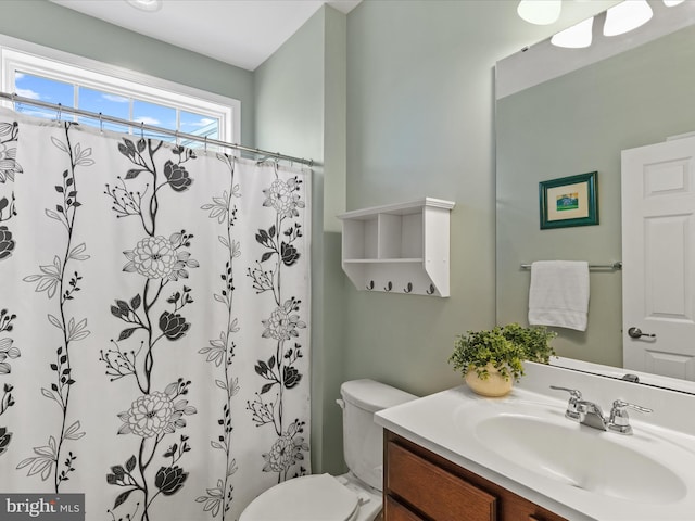 full bathroom featuring toilet, vanity, and a shower with curtain