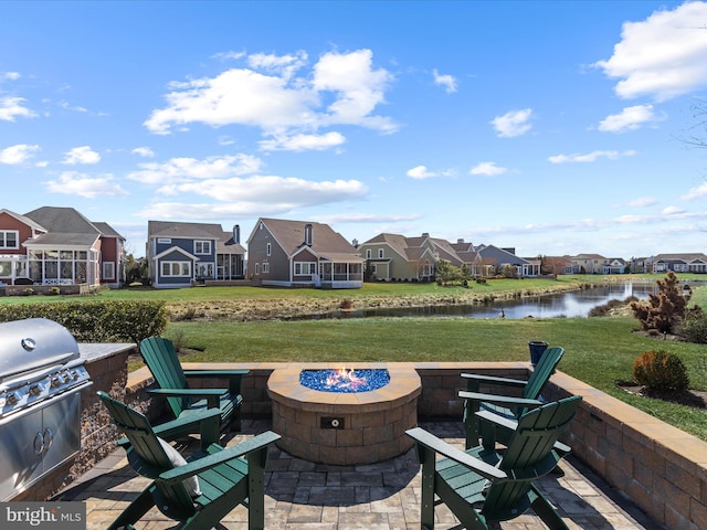 view of patio featuring a fire pit, a water view, a grill, and a residential view