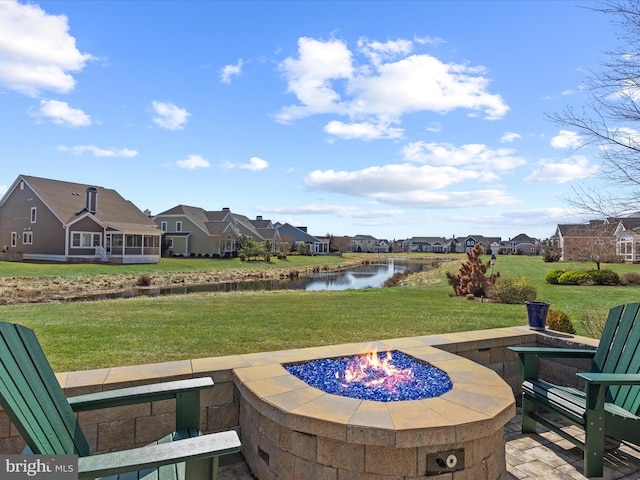 view of patio / terrace with a water view, an outdoor fire pit, and a residential view