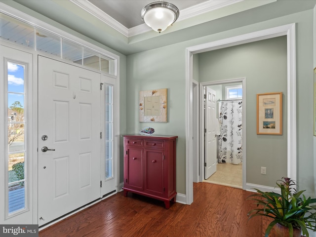 entrance foyer featuring dark wood-style flooring, crown molding, and baseboards