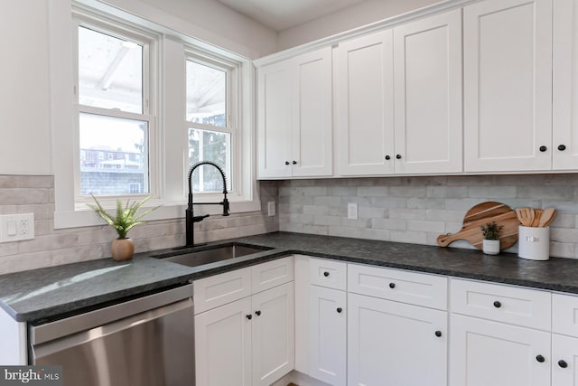 kitchen with stainless steel dishwasher, a sink, white cabinetry, and decorative backsplash